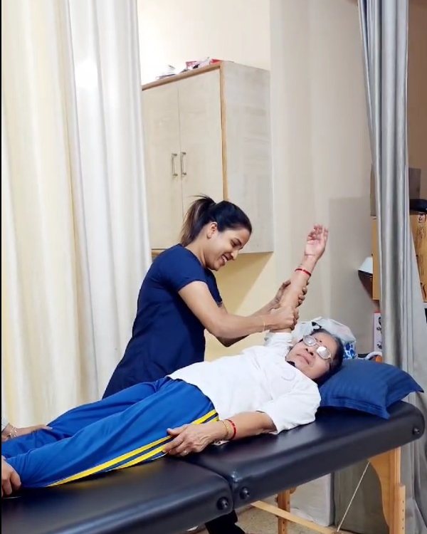Physiotherapist mobilising a patient's arm on the treatment table